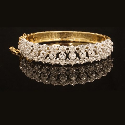 A 18kt gold bangle with 13 diamonds. Size inside: 
5,6x6cm