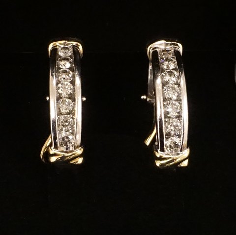 A pair of 14kt gold creole half paved earrings. 
Each with a diamond of circa 0,1ct. Size: 
2,8x0,5x1,4cm