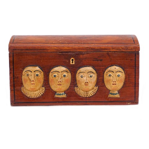 An early 19th century original decorated wooden 
box with wood cut faces. Denmark circa 1800. H: 
14cm. L: 26cm. D: 13cm