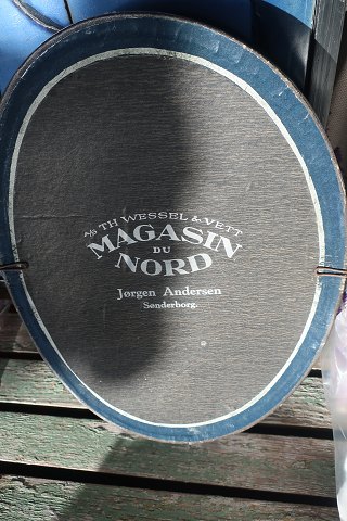 Eine Kiste für ein Klappzylinder Hut (Chapeau Claque)
Von TH. Wessel & Wett Magasin Du Nord, Jørgen Andersen Sønderborg, Dänemark
Bemerken Sie bitte, dass die Kiste aus Magasin Du Nord genau in Sønderborg ist
