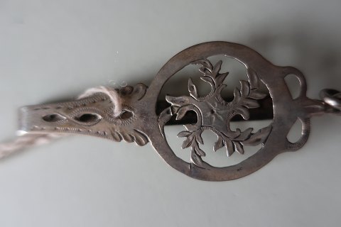 Antik "giljekrog" aus Silber- ein Gerät beim Stricken zu verwenden
1797
Signiert
"Giljekrogen" wird beim Kleid oben links angeschnaltet, und dann wird den 
Garnknäuel an den "Giljekrog" festgemack, und damit war es möglich rund herum zu 
wandern