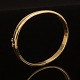 A oval gold bangle of 14kt gold. Size inside: 5,3x6,0cm