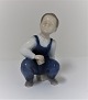 Bing & Grondahl. Porzellanfigur. Sitzender Junge. Modell 2402. Höhe 12 cm. (1 
Wahl)